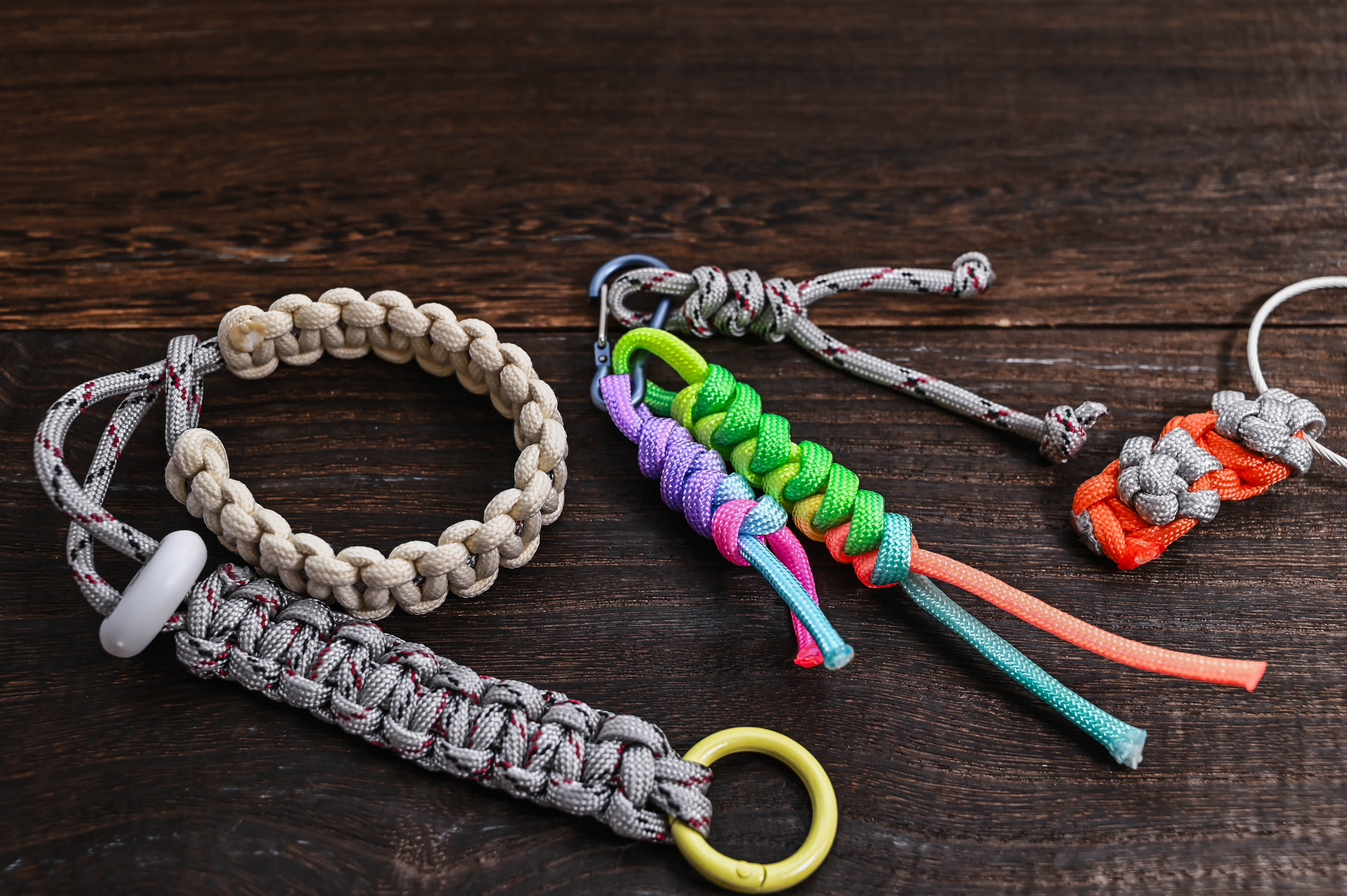Assorted braided ropes and handles laid out on a dark wooden surface.