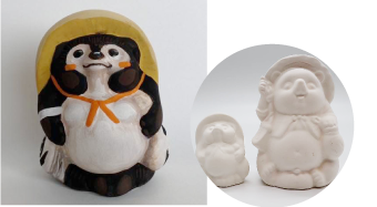 Left: a panda-themed nesting doll with an orange ribbon, next to two white carved bear-like figurines on the right.